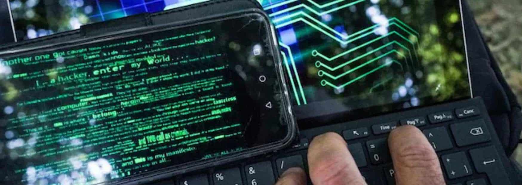 evoluzione degli attacchi hacker un hacker utilizza uno smartphone e una tastiera per sferrare un attacco informatico di phishing.